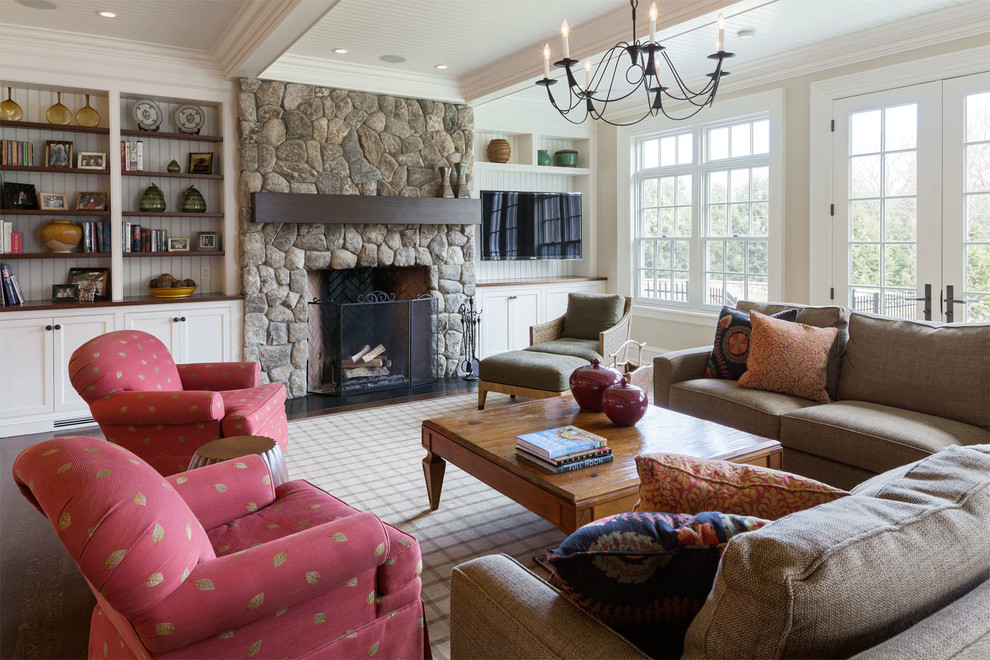 Imagen de sala de estar abierta tradicional grande con paredes beige, suelo de madera oscura, todas las chimeneas y marco de chimenea de piedra