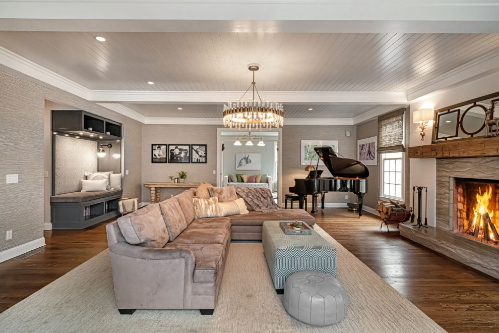 Expansive traditional enclosed games room in New York with a music area, grey walls, medium hardwood flooring, a standard fireplace, a tiled fireplace surround, no tv and brown floors.