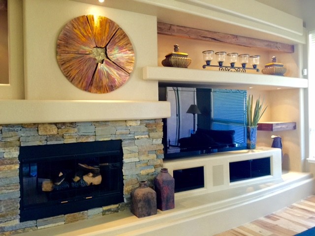 Foto de sala de estar abierta contemporánea grande con paredes beige, suelo de madera clara, todas las chimeneas, marco de chimenea de piedra, televisor independiente y suelo marrón