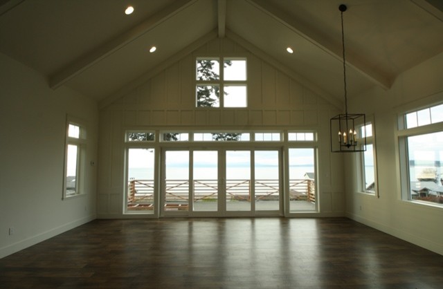 Imagen de sala de estar abierta costera de tamaño medio sin chimenea con paredes blancas