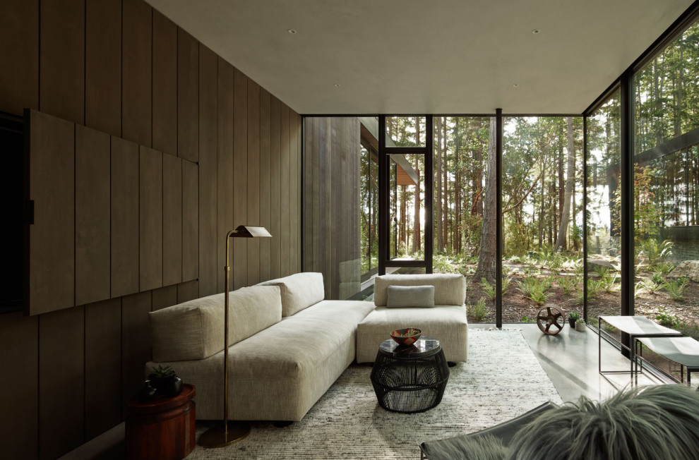 На фото: гостиная комната в стиле модернизм с коричневыми стенами, бетонным полом, серым полом и деревянными стенами