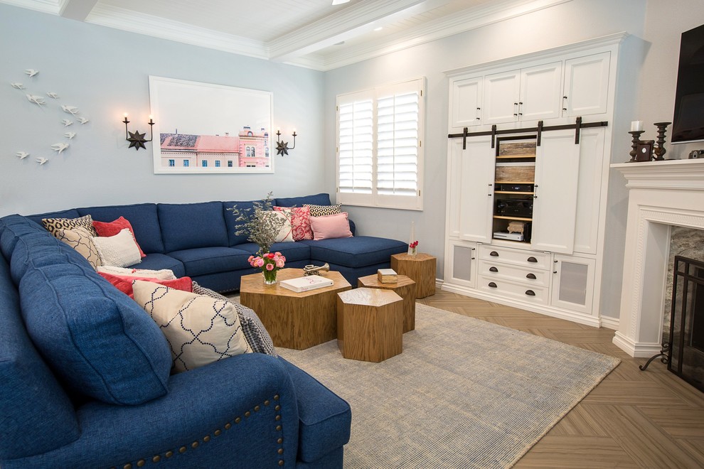 Ejemplo de sala de estar abierta clásica renovada grande con paredes azules, suelo de baldosas de cerámica, chimenea de esquina, marco de chimenea de madera, televisor colgado en la pared y suelo marrón