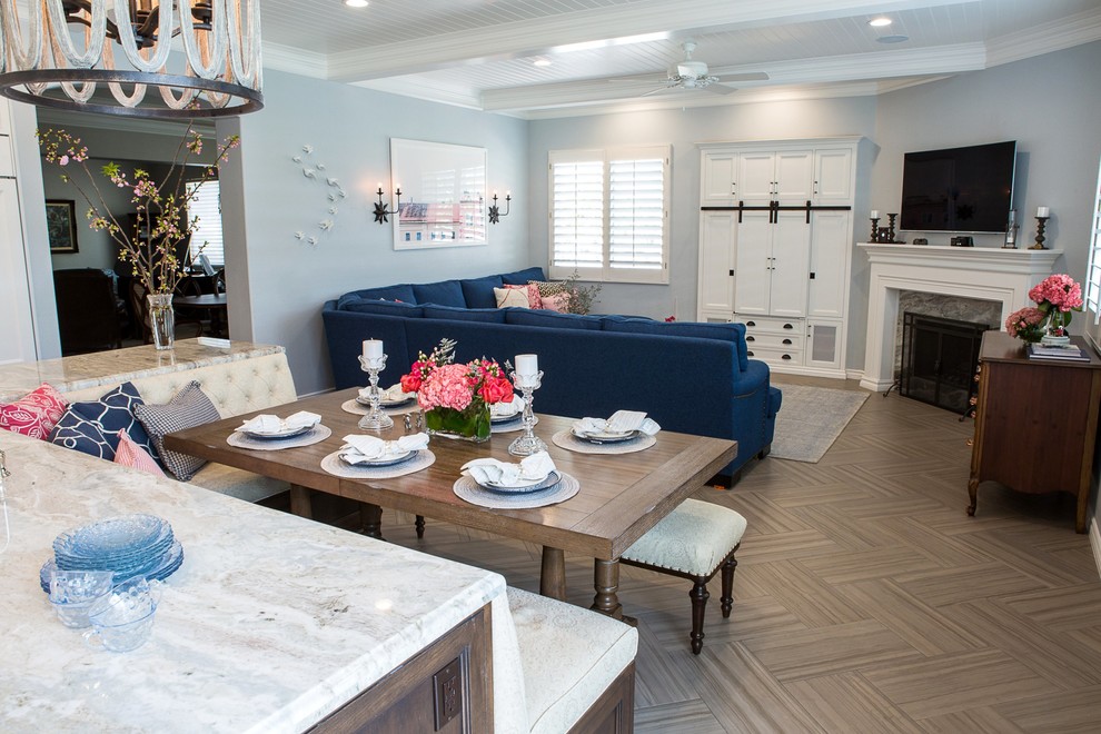 Cette image montre une grande salle de séjour traditionnelle ouverte avec un mur bleu, un sol en carrelage de céramique, une cheminée d'angle, un manteau de cheminée en bois, un téléviseur fixé au mur et un sol marron.