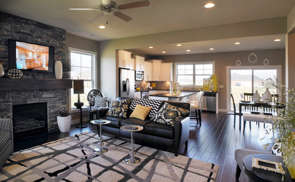 Example of a mid-sized transitional open concept family room design in Other with gray walls, a standard fireplace, a stone fireplace and a wall-mounted tv