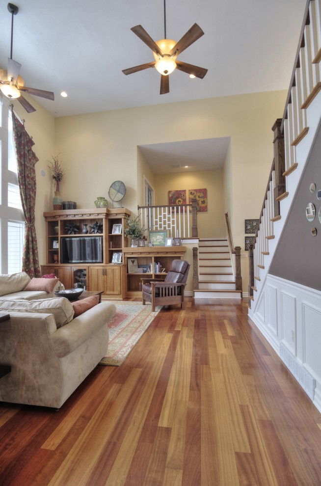 Foto de sala de estar abierta tradicional renovada grande con paredes amarillas y suelo de madera en tonos medios