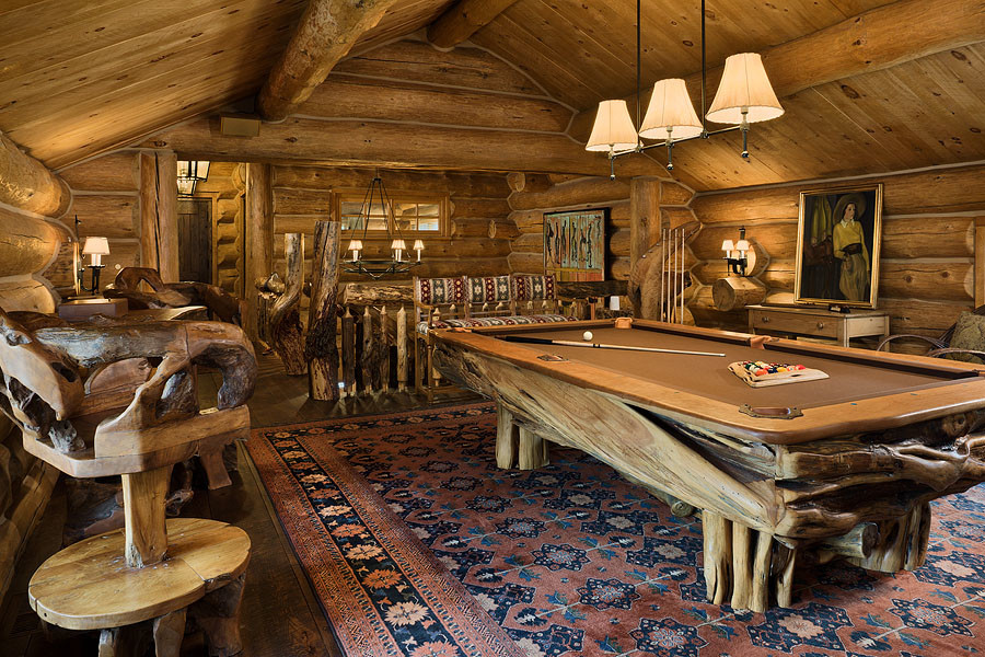 Imagen de sala de juegos en casa tipo loft rural extra grande sin televisor con paredes marrones y suelo de madera oscura