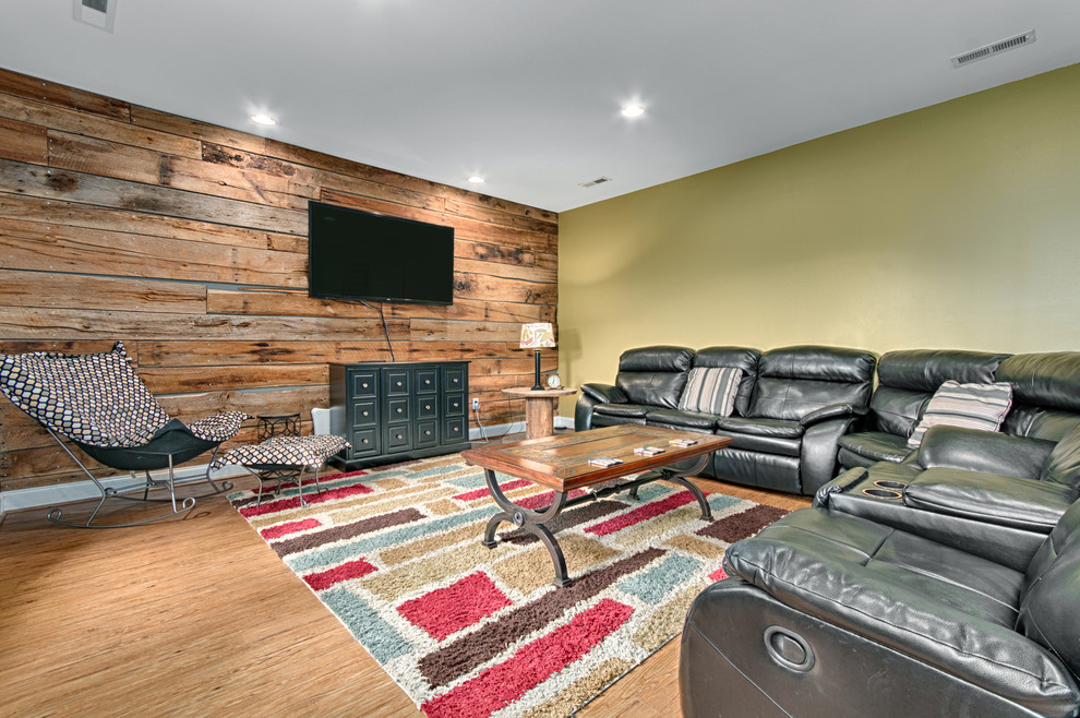 Ejemplo de sala de juegos en casa abierta minimalista grande sin chimenea con paredes verdes, suelo de madera clara y televisor colgado en la pared