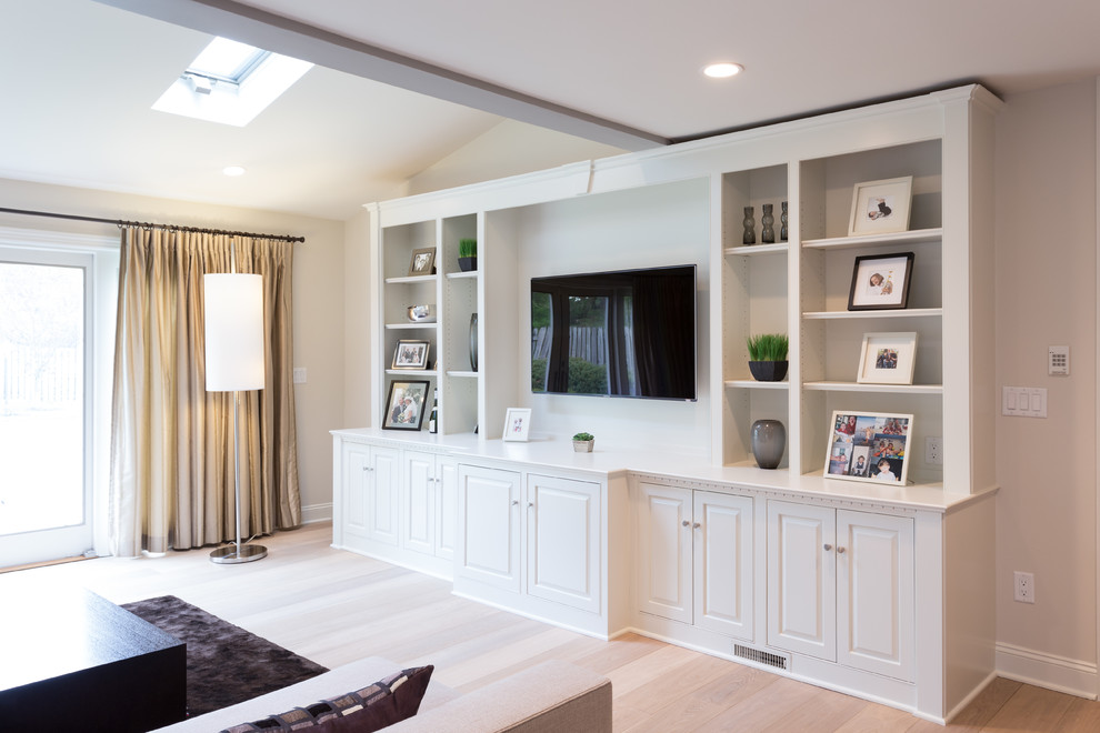 Imagen de sala de estar abierta retro grande con paredes beige, suelo de madera clara, chimenea de doble cara, marco de chimenea de piedra y pared multimedia