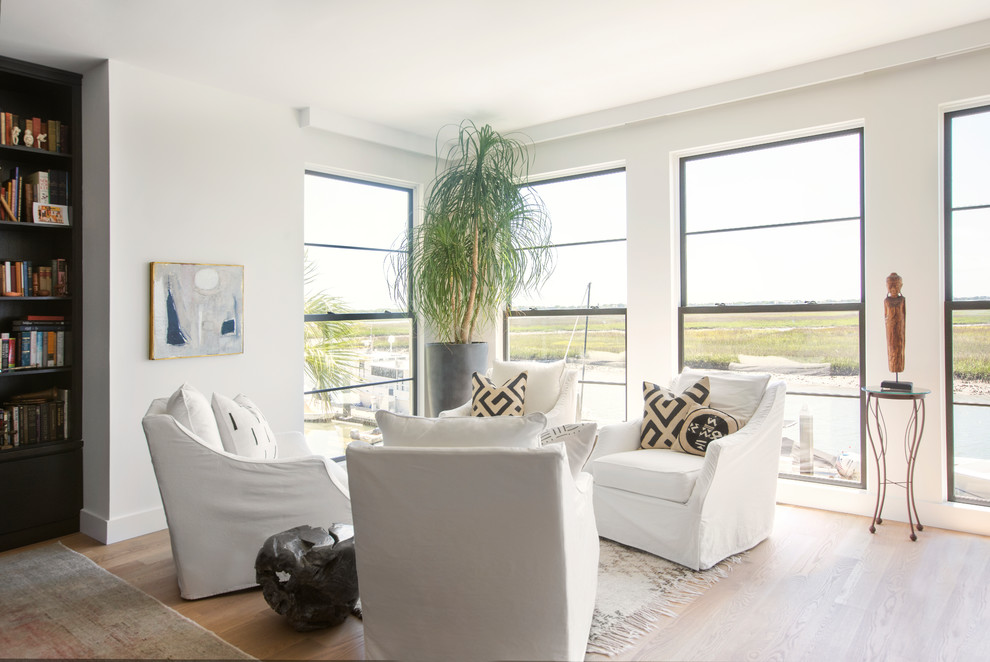 Imagen de sala de estar abierta actual con paredes blancas y suelo de madera clara
