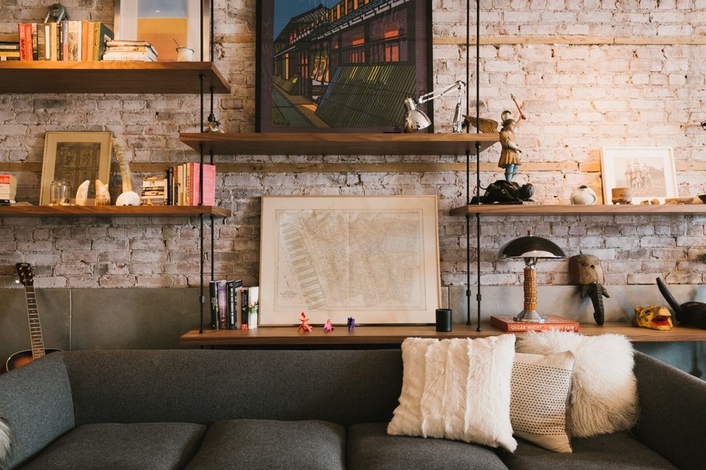 Imagen de sala de estar urbana de tamaño medio con paredes rojas, suelo de madera clara, todas las chimeneas y marco de chimenea de piedra