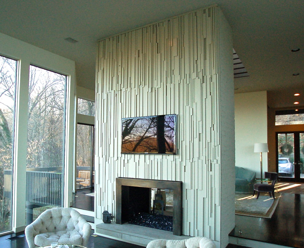 Foto di un grande soggiorno minimalista aperto con pareti bianche, parquet scuro, camino bifacciale, TV a parete e cornice del camino in metallo