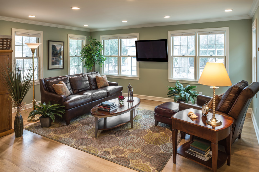 Mid-sized transitional enclosed light wood floor family room photo in Milwaukee with green walls and a wall-mounted tv