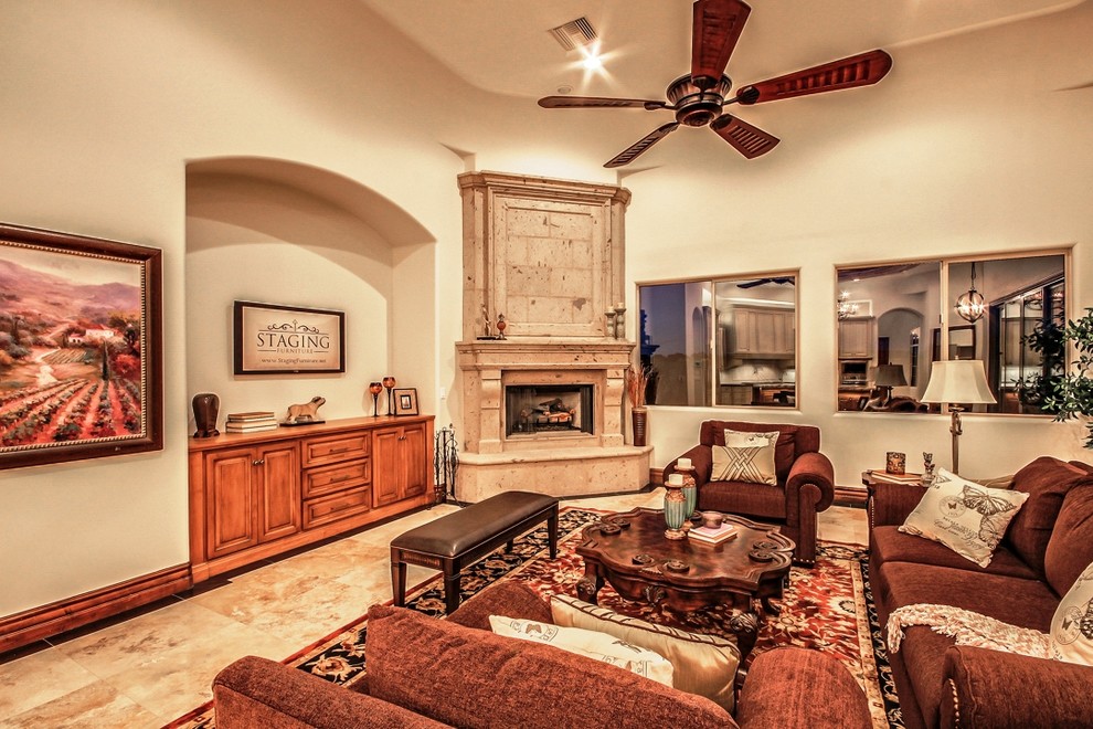 Diseño de sala de estar abierta mediterránea de tamaño medio sin televisor con paredes beige, suelo de travertino, chimenea de esquina y marco de chimenea de piedra