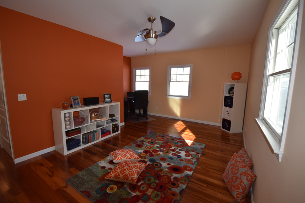 Стильный дизайн: изолированная гостиная комната среднего размера в стиле неоклассика (современная классика) с оранжевыми стенами и паркетным полом среднего тона - последний тренд