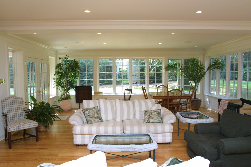 Diseño de sala de estar abierta tradicional grande sin chimenea con suelo de madera clara