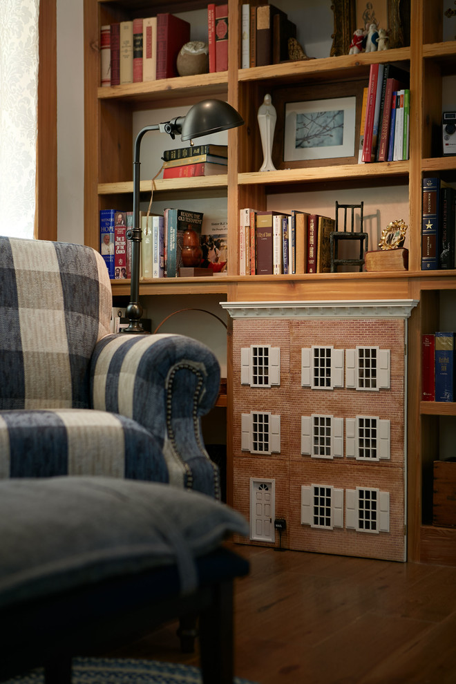 Modelo de sala de estar con biblioteca tipo loft de estilo de casa de campo de tamaño medio con paredes blancas, suelo de madera oscura y suelo marrón