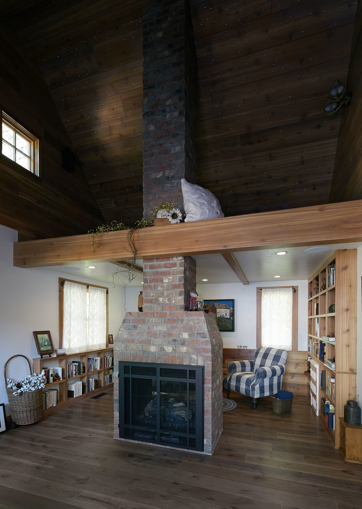 Immagine di un soggiorno chic di medie dimensioni e stile loft con libreria, pareti bianche, parquet scuro e pavimento marrone
