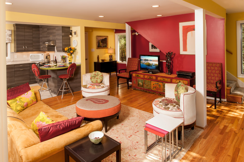 Свежая идея для дизайна: открытая гостиная комната в стиле фьюжн с красными стенами, паркетным полом среднего тона и отдельно стоящим телевизором - отличное фото интерьера