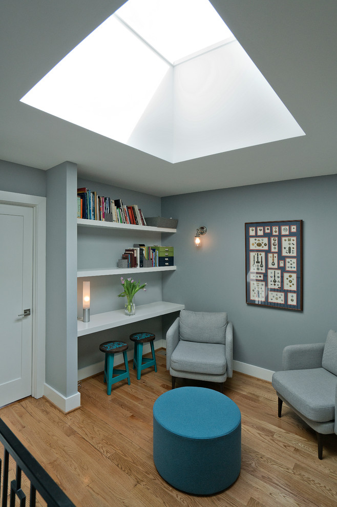 Foto di un piccolo soggiorno classico aperto con libreria, pavimento in legno massello medio, pareti grigie, nessun camino e pavimento marrone