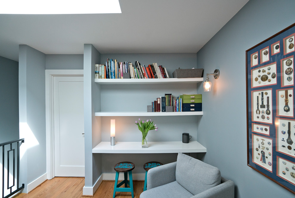 Aménagement d'une petite salle de séjour classique ouverte avec une bibliothèque ou un coin lecture, un sol en bois brun, un mur gris, aucune cheminée et un sol marron.