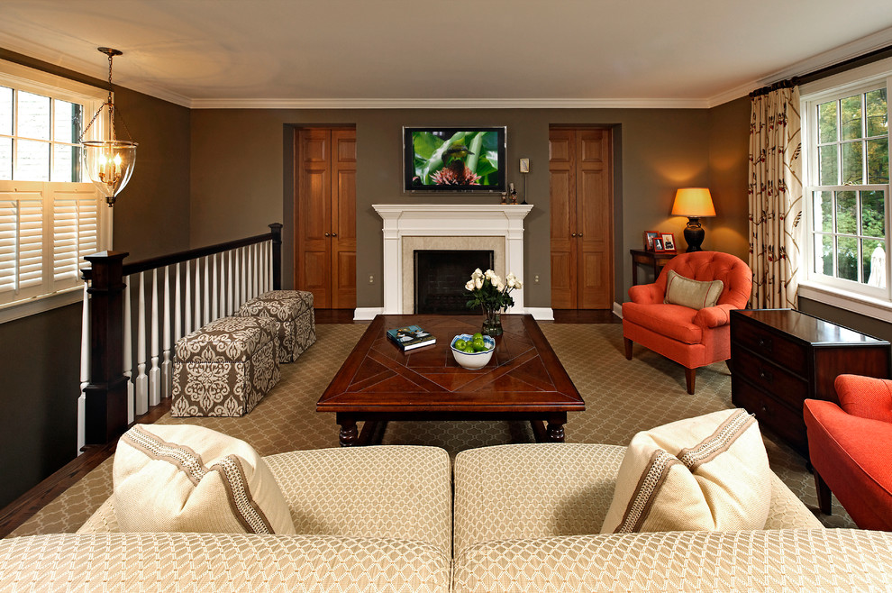 Inredning av ett klassiskt allrum på loftet, med bruna väggar, en standard öppen spis, en väggmonterad TV och en spiselkrans i trä