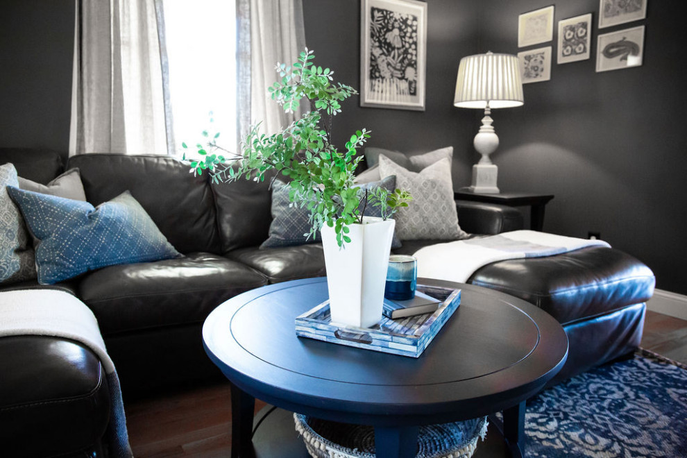 Modelo de sala de estar cerrada clásica renovada de tamaño medio con paredes azules, suelo de madera en tonos medios, televisor colgado en la pared y suelo marrón