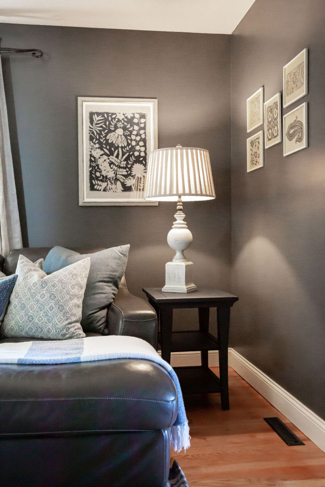 Imagen de sala de estar cerrada tradicional renovada de tamaño medio con paredes azules, suelo de madera en tonos medios, televisor colgado en la pared y suelo marrón