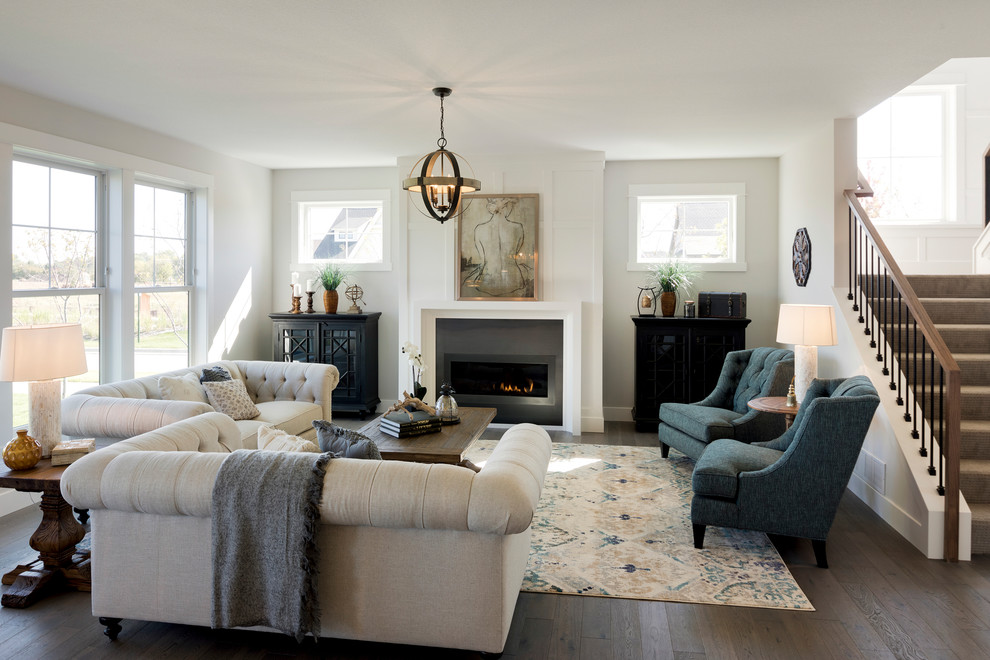 Foto de sala de estar tradicional renovada con suelo de madera oscura, chimenea lineal y marco de chimenea de metal