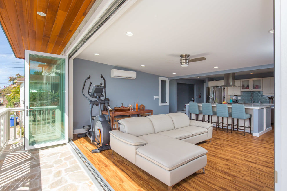 Inspiration for a large transitional open concept light wood floor family room remodel in Hawaii with blue walls, no fireplace and a tv stand