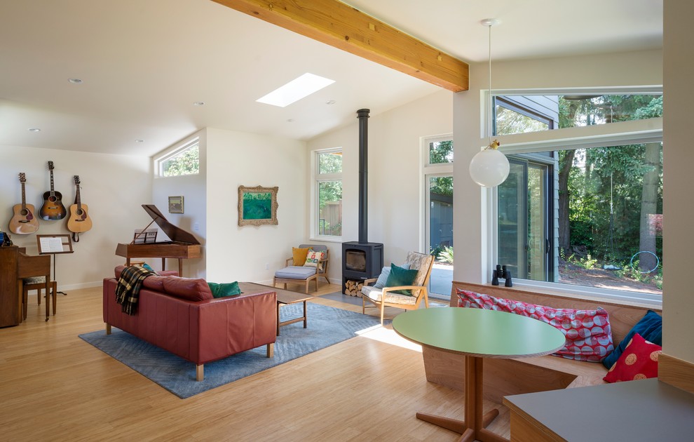 Cette photo montre une salle de séjour rétro de taille moyenne et ouverte avec une salle de musique et un sol en bois brun.