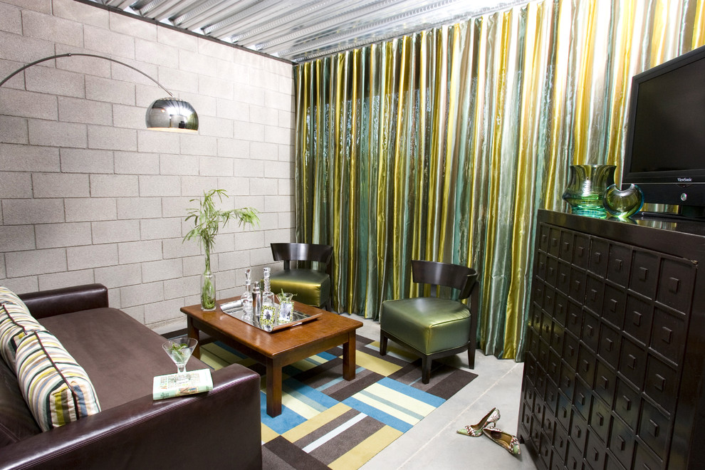 Kleines Industrial Wohnzimmer im Loft-Stil mit Betonboden, freistehendem TV und grauer Wandfarbe in Phoenix