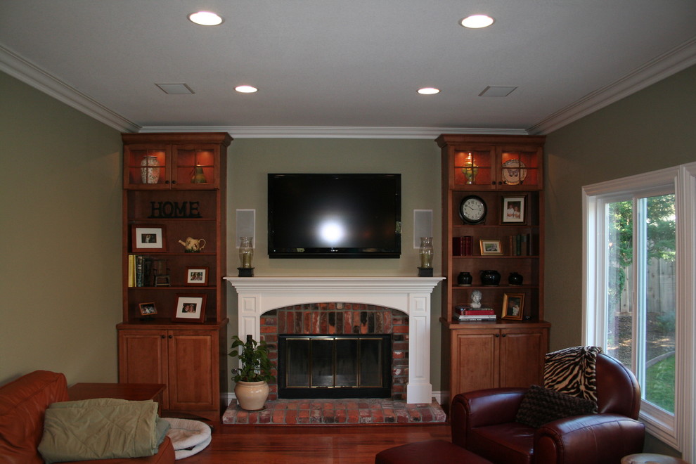 Inspiration for a medium sized traditional enclosed games room in San Francisco with medium hardwood flooring, a reading nook, green walls, a standard fireplace, a brick fireplace surround and a wall mounted tv.