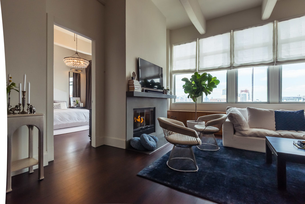 Foto de sala de estar abierta clásica renovada de tamaño medio con paredes beige, suelo de madera oscura, chimenea lineal, marco de chimenea de hormigón y televisor independiente