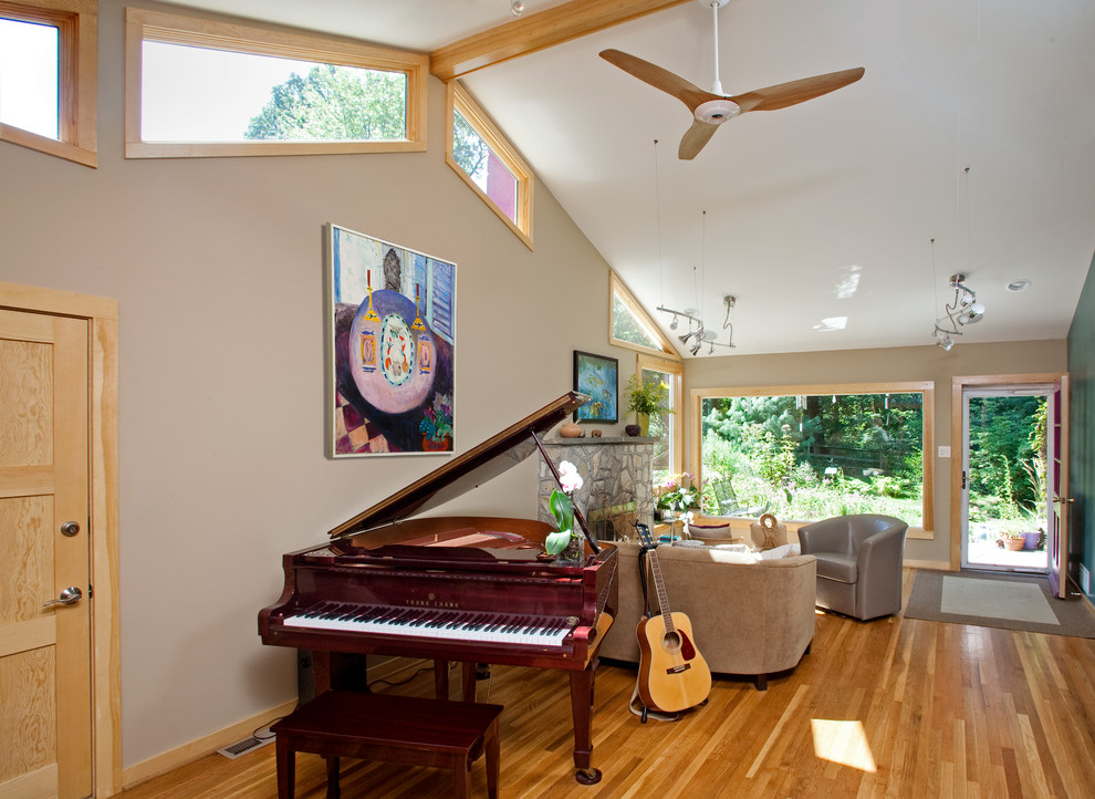 Mid-sized eclectic open concept medium tone wood floor family room photo in Philadelphia with a music area, beige walls, a standard fireplace, a stone fireplace and no tv