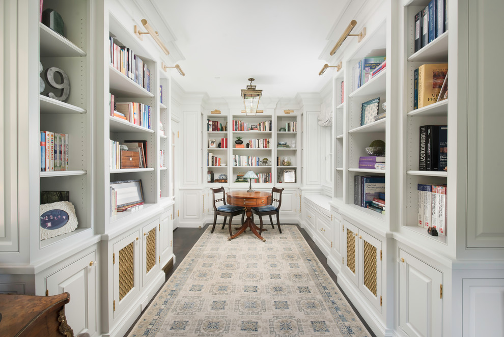Inspiration pour une salle de séjour traditionnelle fermée avec une bibliothèque ou un coin lecture, un mur blanc, parquet foncé et un sol marron.