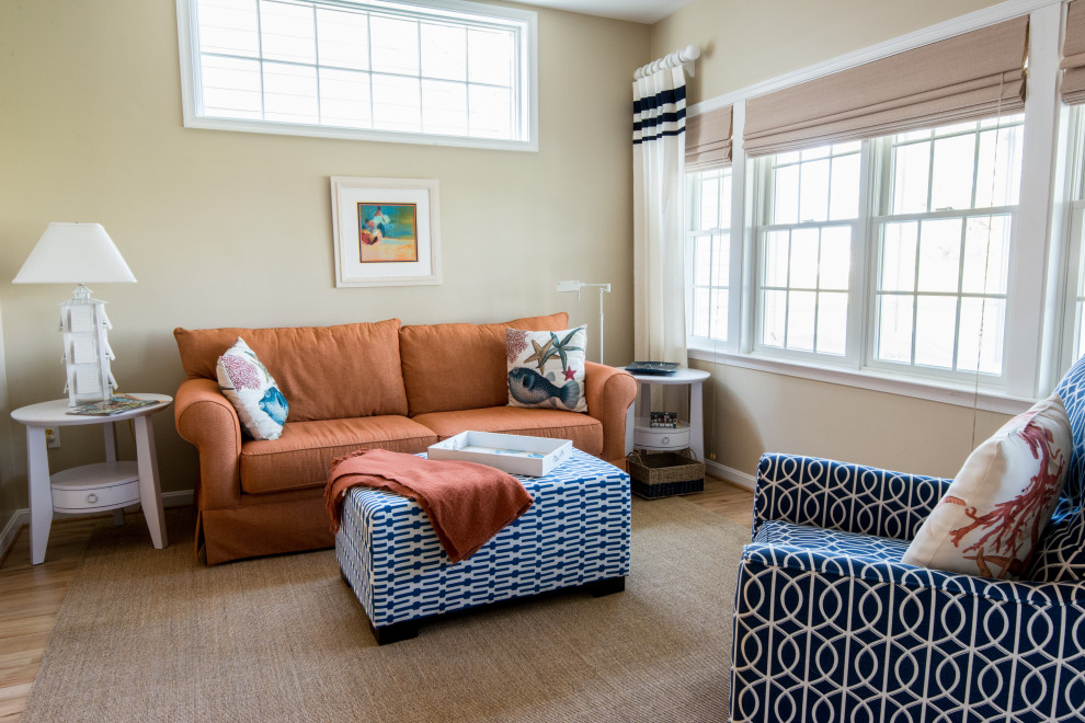 Ejemplo de sala de estar abierta marinera grande con paredes beige y suelo de madera clara