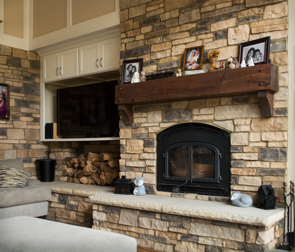 Large mountain style open concept light wood floor family room photo in Charlotte with beige walls, a standard fireplace, a stone fireplace and a media wall