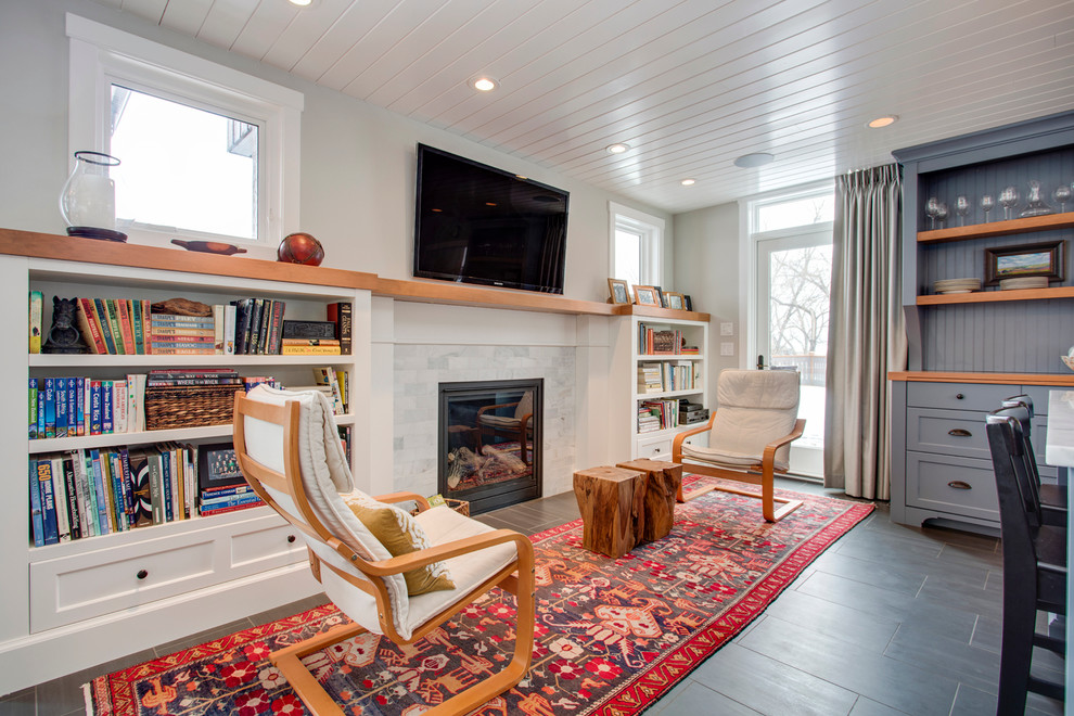 This is an example of a rural open plan living room in Calgary with grey walls, porcelain flooring, a standard fireplace, a stone fireplace surround and a wall mounted tv.