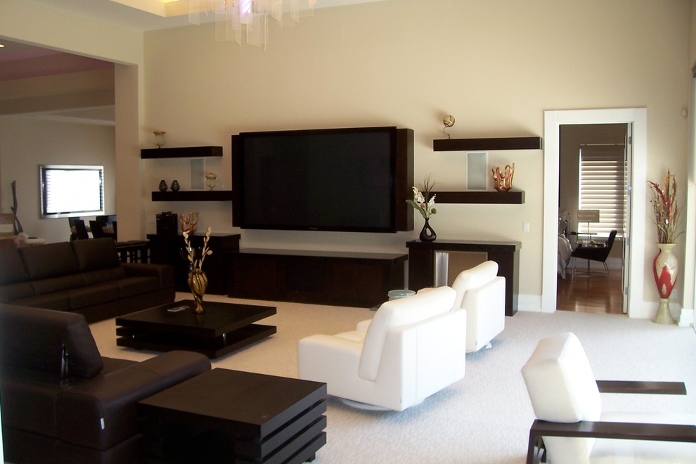 Ejemplo de sala de estar actual extra grande con chimeneas suspendidas, marco de chimenea de madera y televisor colgado en la pared