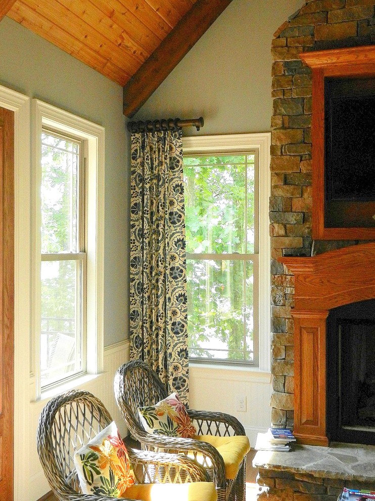 На фото: гостиная комната в стиле рустика с синими стенами, стандартным камином и фасадом камина из кирпича с