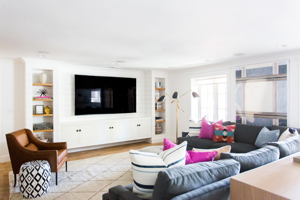 Cette photo montre une salle de séjour bord de mer de taille moyenne avec un mur blanc, parquet clair, un téléviseur encastré et un sol beige.