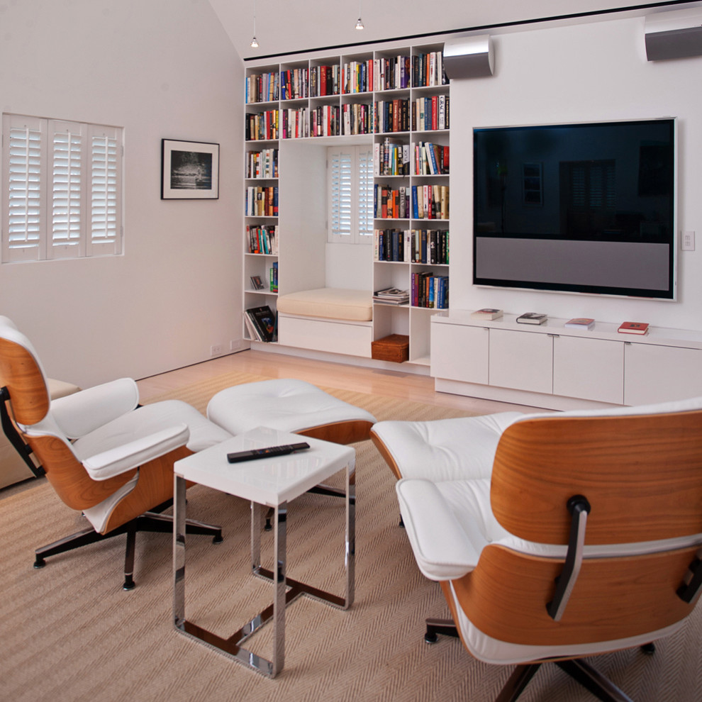 Пример оригинального дизайна: гостиная комната в современном стиле с белыми стенами и телевизором на стене