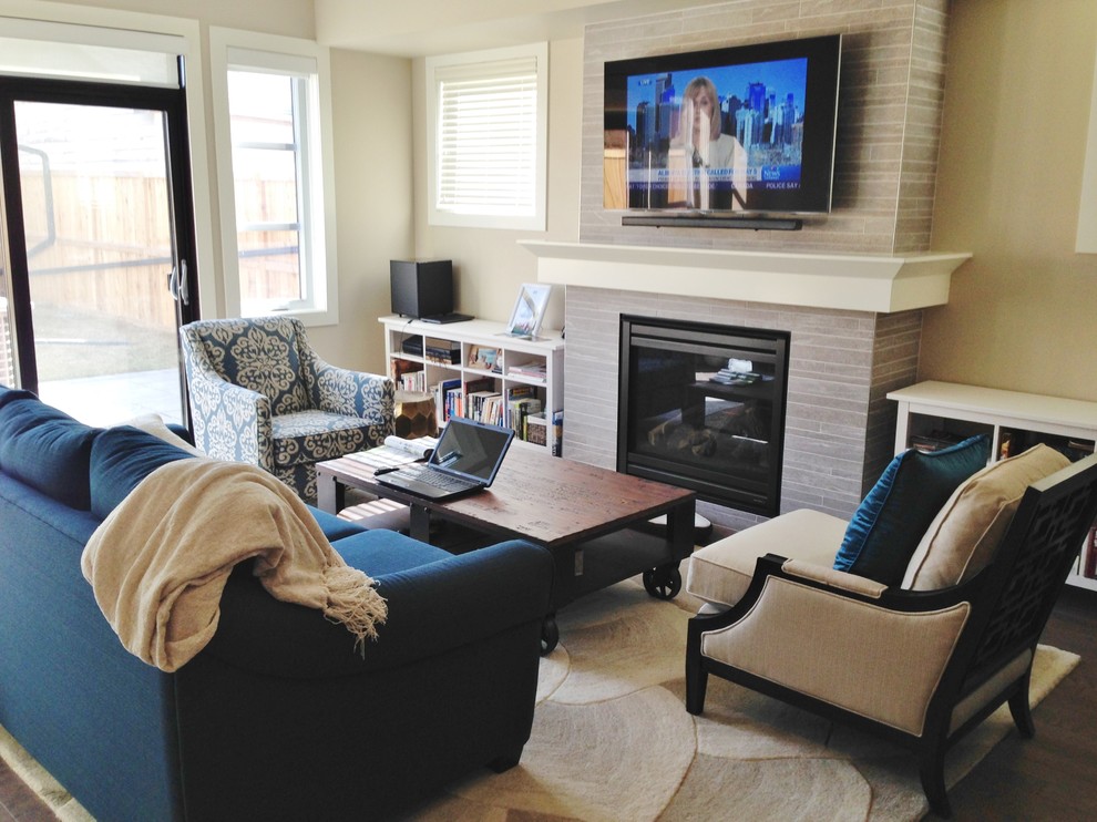 Mittelgroßes, Abgetrenntes Klassisches Wohnzimmer mit beiger Wandfarbe, dunklem Holzboden, Kamin, gefliester Kaminumrandung, TV-Wand und braunem Boden in Calgary