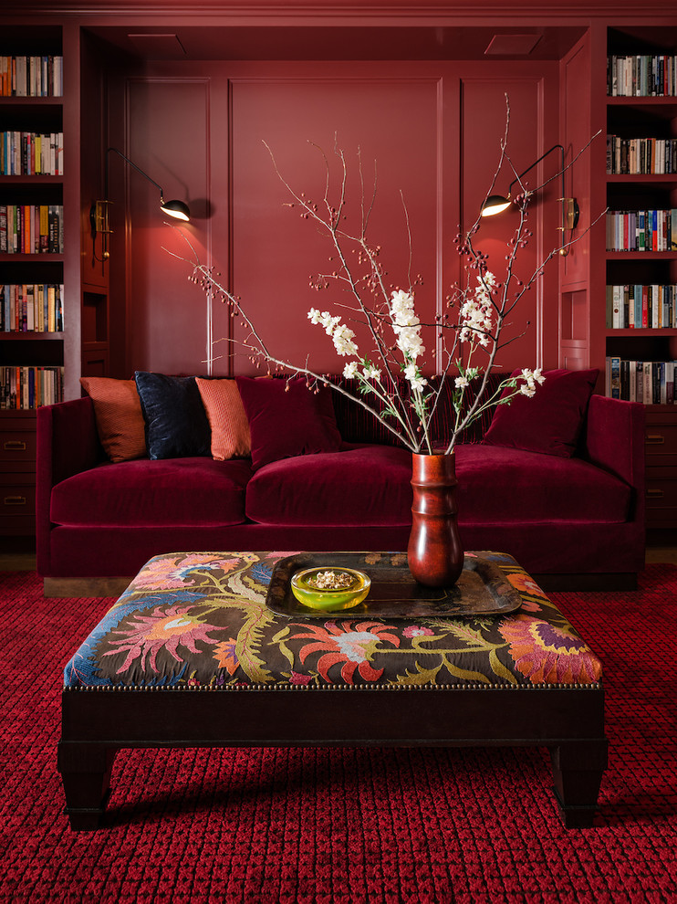 На фото: изолированная гостиная комната среднего размера в современном стиле с с книжными шкафами и полками, красными стенами и ковровым покрытием