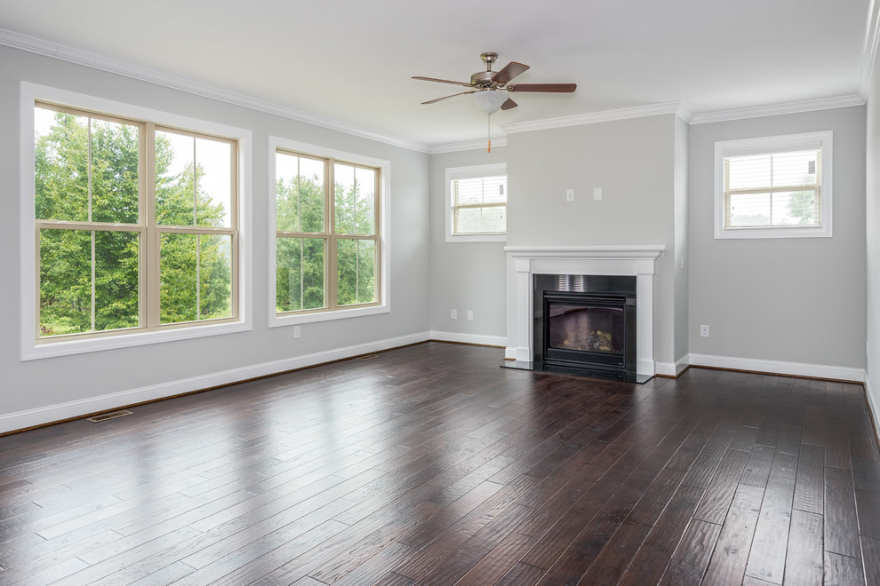This is an example of a large traditional open plan games room in Other with white walls, dark hardwood flooring, a standard fireplace, a tiled fireplace surround, no tv and brown floors.