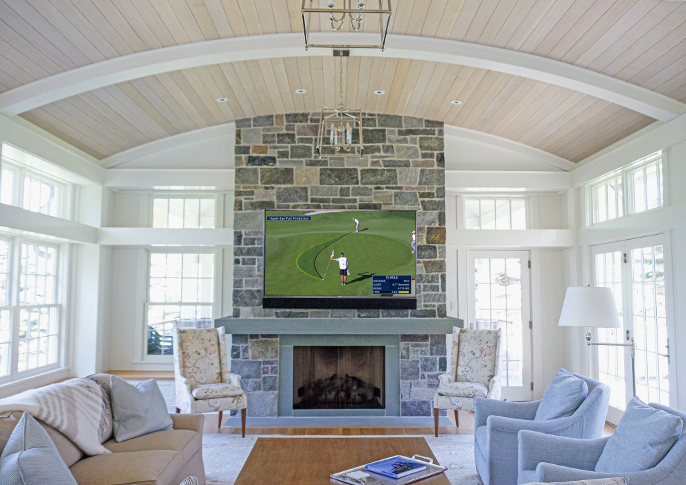 Expansive beach style games room in Minneapolis with white walls, light hardwood flooring, a standard fireplace, a stone fireplace surround, brown floors, a timber clad ceiling and wainscoting.