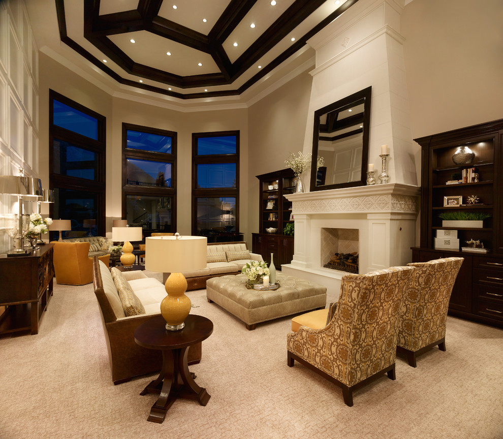 На фото: открытая гостиная комната в классическом стиле с бежевыми стенами, ковровым покрытием, стандартным камином, фасадом камина из штукатурки и скрытым телевизором