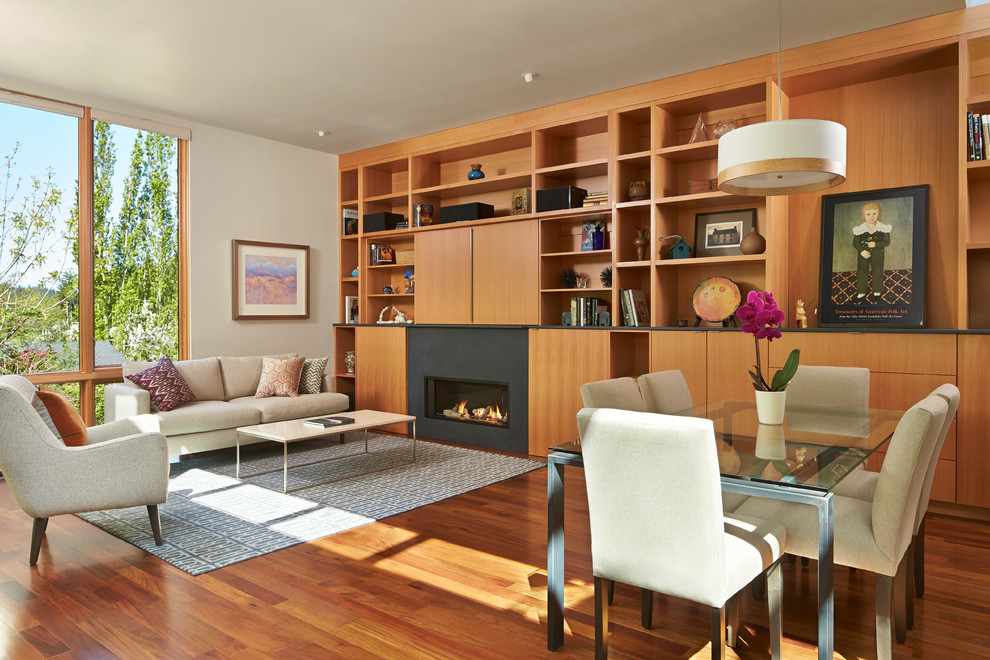 Immagine di un soggiorno design aperto con libreria, pavimento in legno massello medio, camino lineare Ribbon e TV nascosta