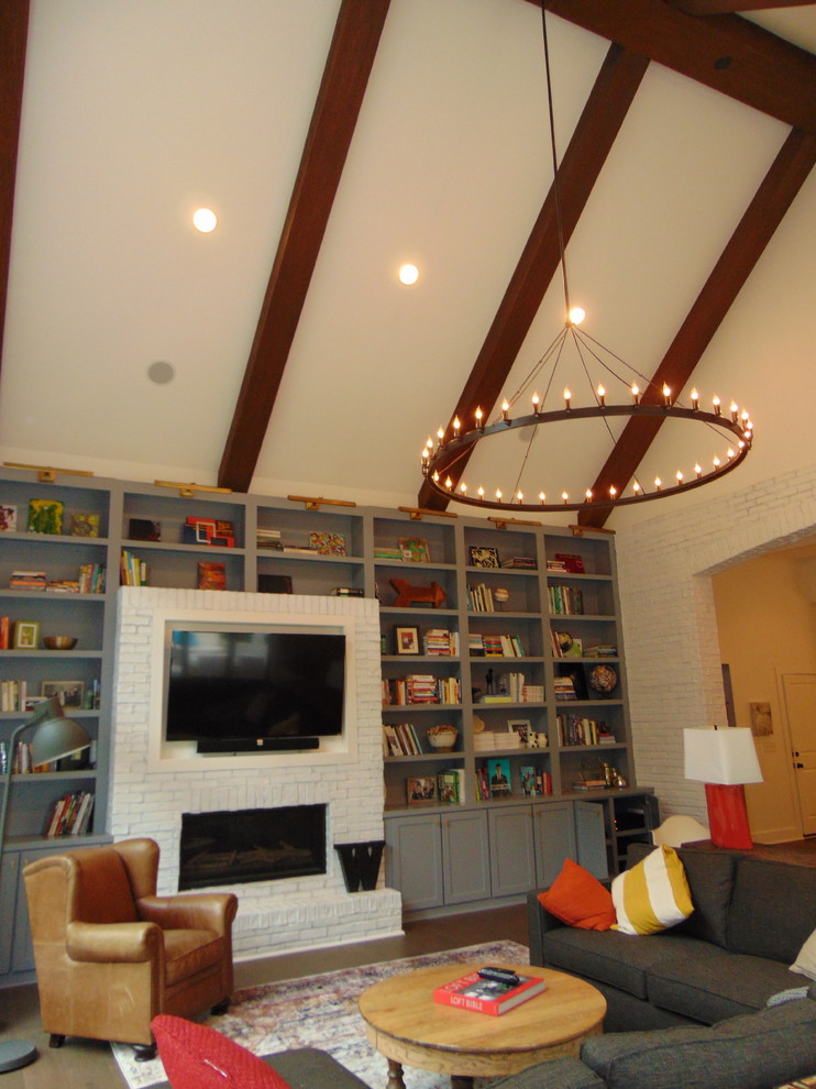 Imagen de sala de estar abierta contemporánea de tamaño medio con paredes blancas, suelo de madera oscura, todas las chimeneas, marco de chimenea de ladrillo, televisor colgado en la pared y suelo marrón