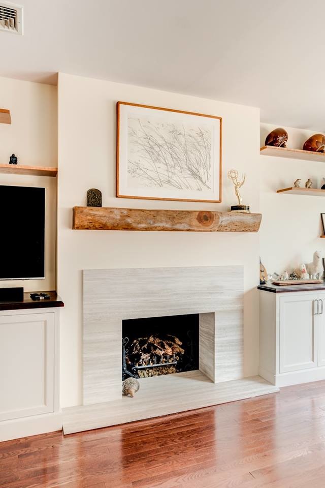 Esempio di un soggiorno minimalista di medie dimensioni e chiuso con pareti beige, pavimento in legno massello medio, camino classico, cornice del camino in pietra e TV a parete